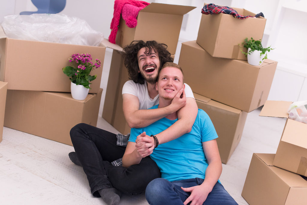 Couple sitting on floor with boxes at new apartment